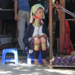 A l'entrée d'un temple, une femme-girafe sert d'appât aux touristes...